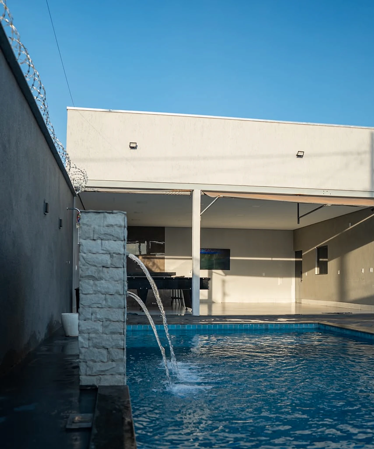 Cascata da piscina com o salão ao fundo