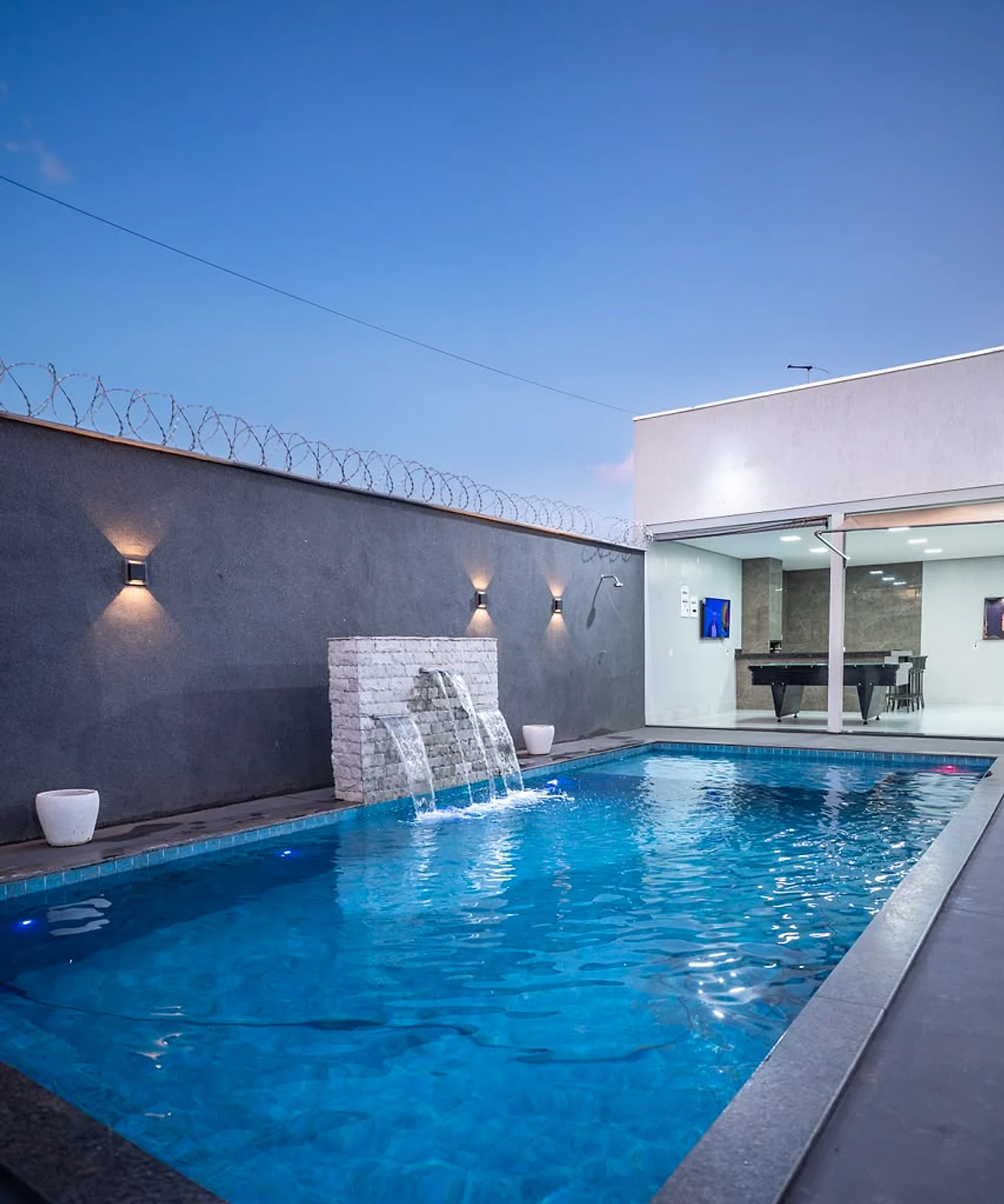 Piscina com cascata ao entardecer