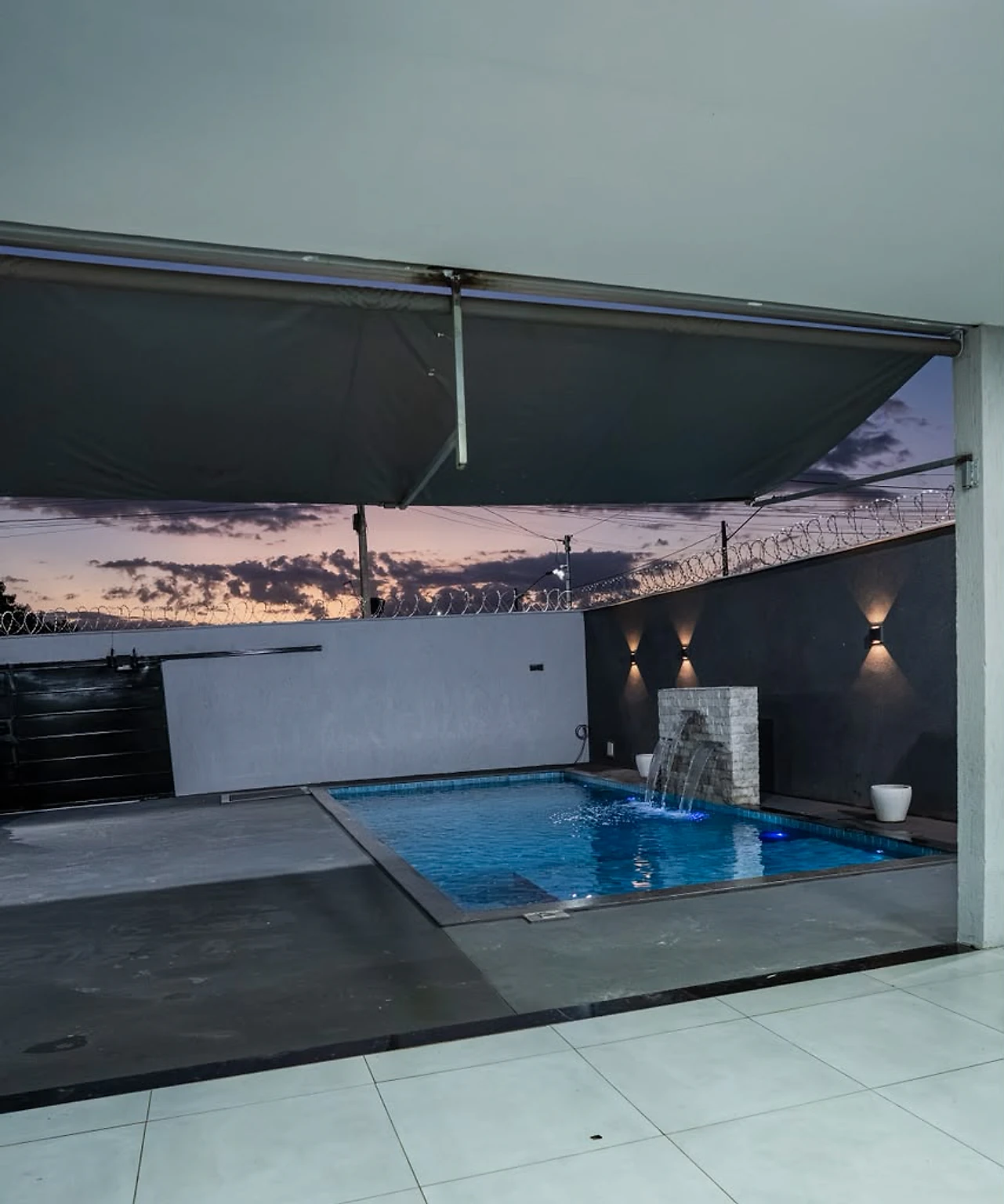 Piscina com cascata iluminada à noite